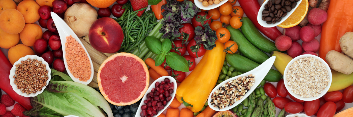 An array of healthy fresh produce, legumes, nuts, and seeds.
