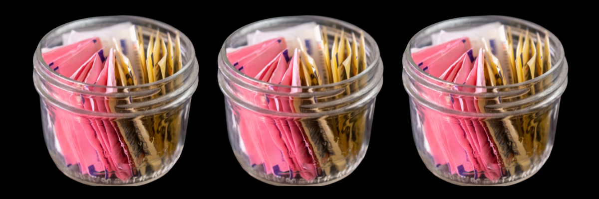 Three containers of various popular artificial sweeteners.