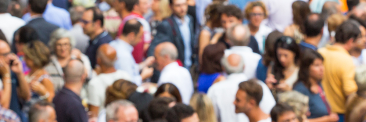 A blurred image of a large crowd of people.