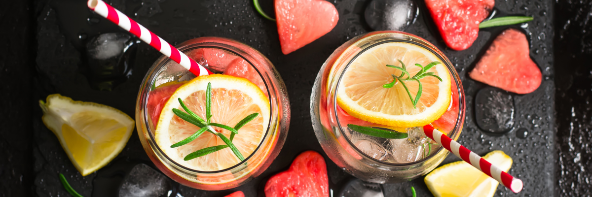 Watermelon-Rosemary Citrus Infused Water on a dark stone surface with heart-shaped watermelon pieces.