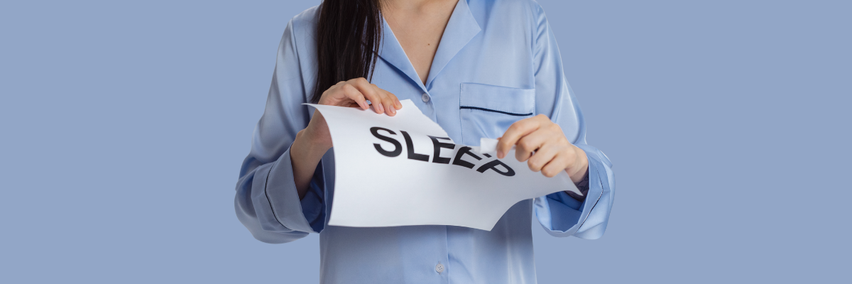 Woman in pajamas ripping a paper that reads: sleep.