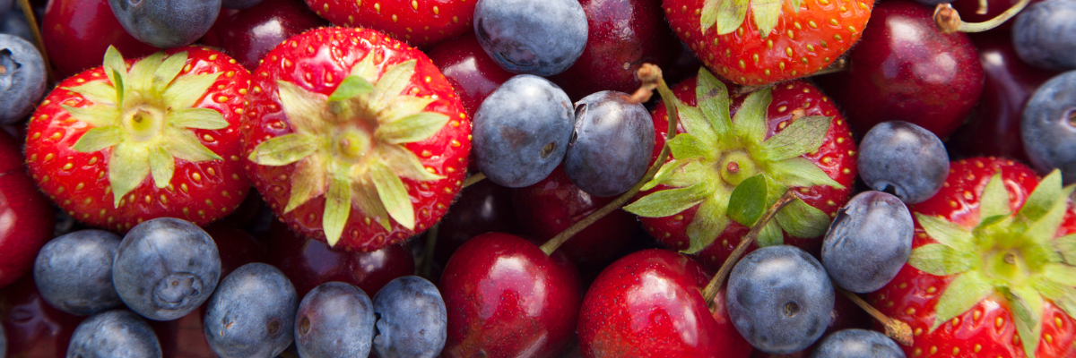 A close-up image of blueberries, grapes, and strawberries.