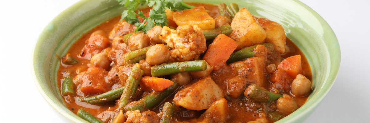 A green bowl of vegetable curry.