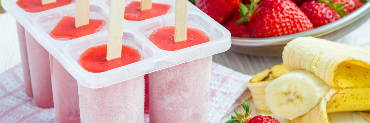 Fiber-Rich Strawberry Banana Freezer Pops in molds with fresh strawberries and bananas.