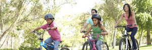 A family of four riding bicycles in a park. 