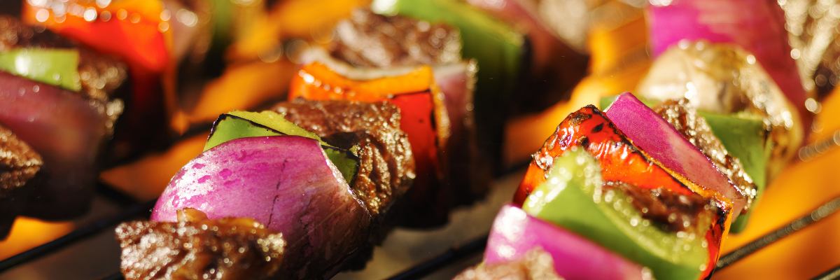 Meat and vegetable kababs on a barbeque grill.