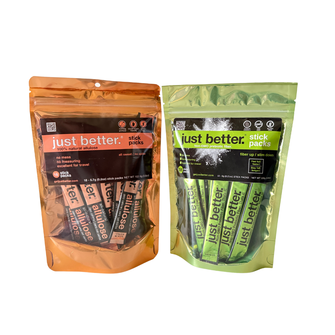 Two packages of 'just better' stick packs, one orange and one green, on a white background.